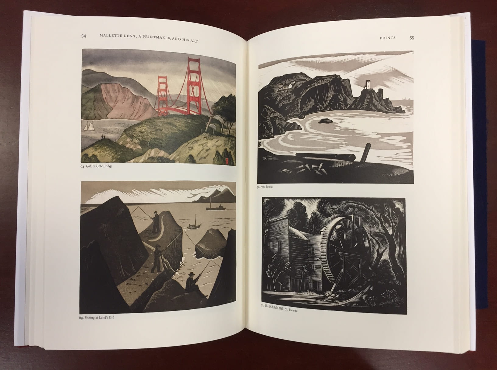 open pages of John Hawk's book featuring Mallette Dean's prints of California coast and the Golden Gate Bridge