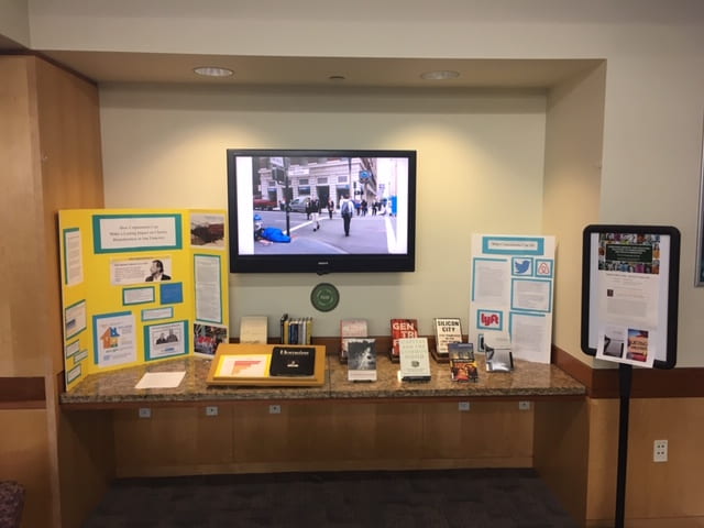 display of student projects on Corporations and Homelessness with books and handouts for more information