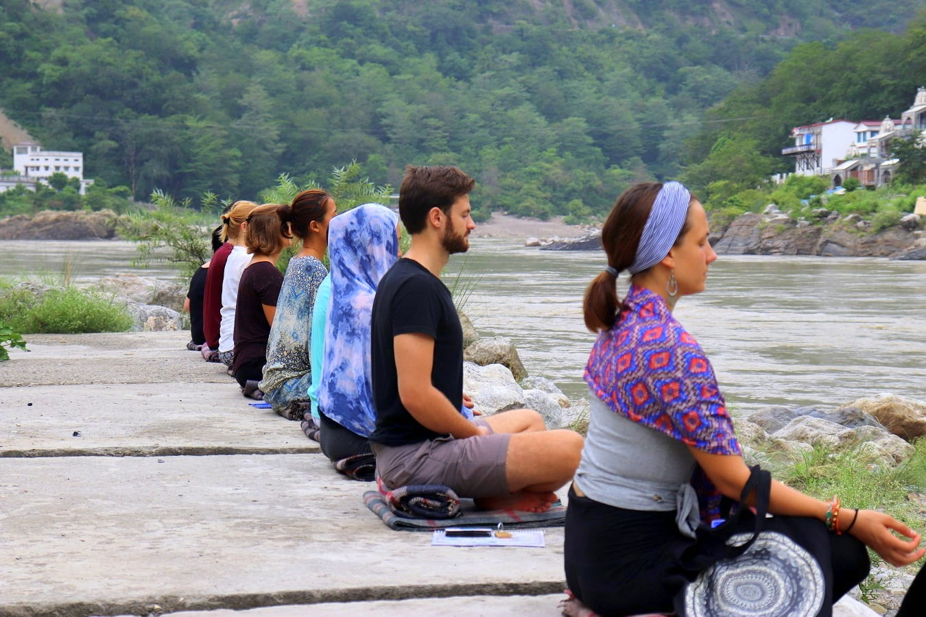 Image of people meditating near a body of water