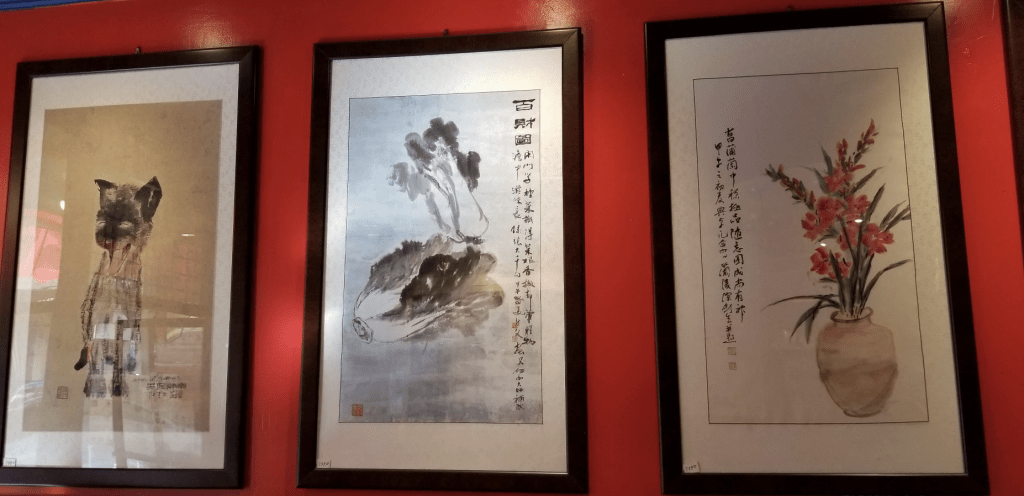 Three traditional Chinese ink painting hanging on a red wall