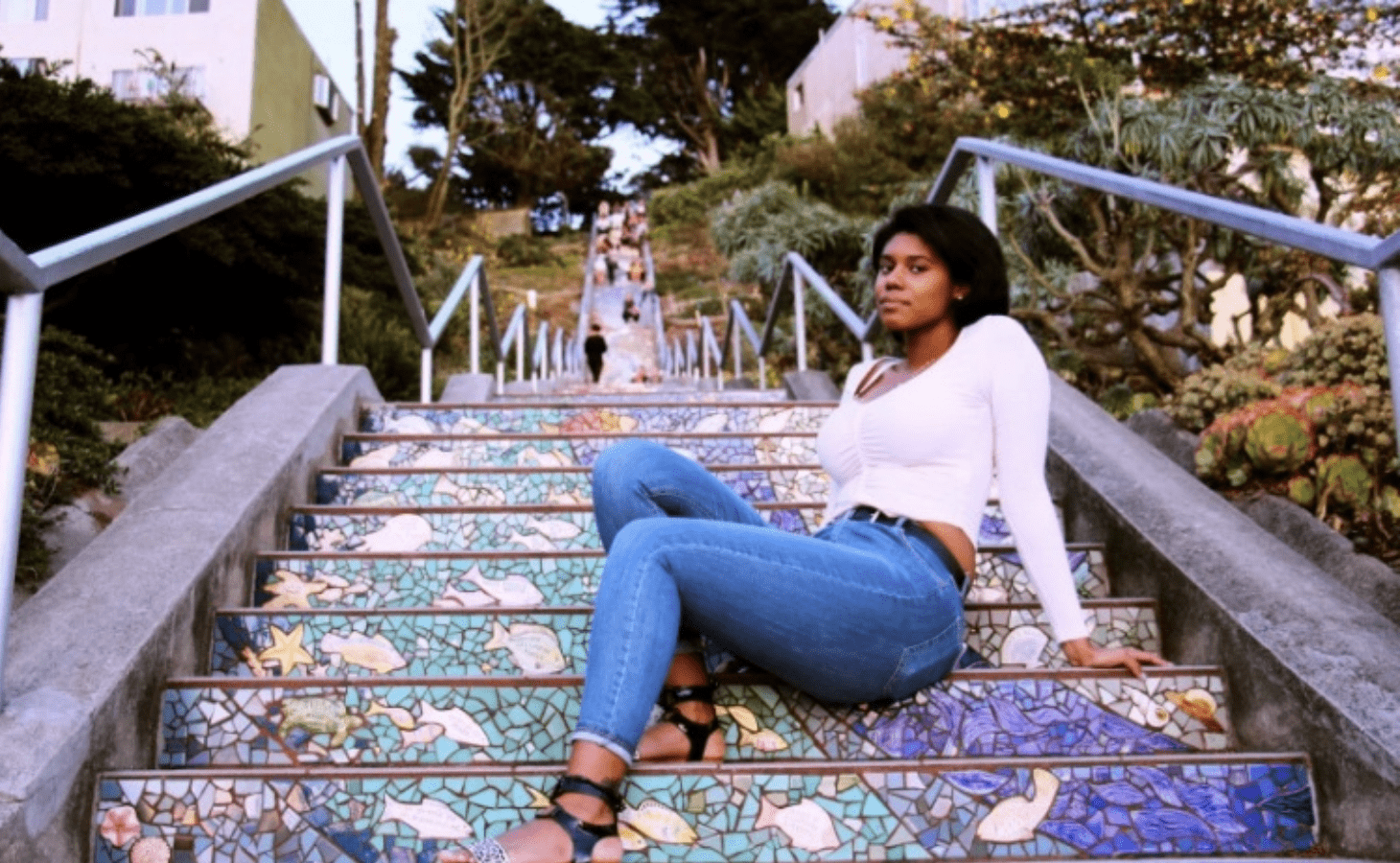woman sitting on colorful staircase