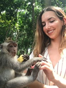 a young woman holding a monkey and smiling