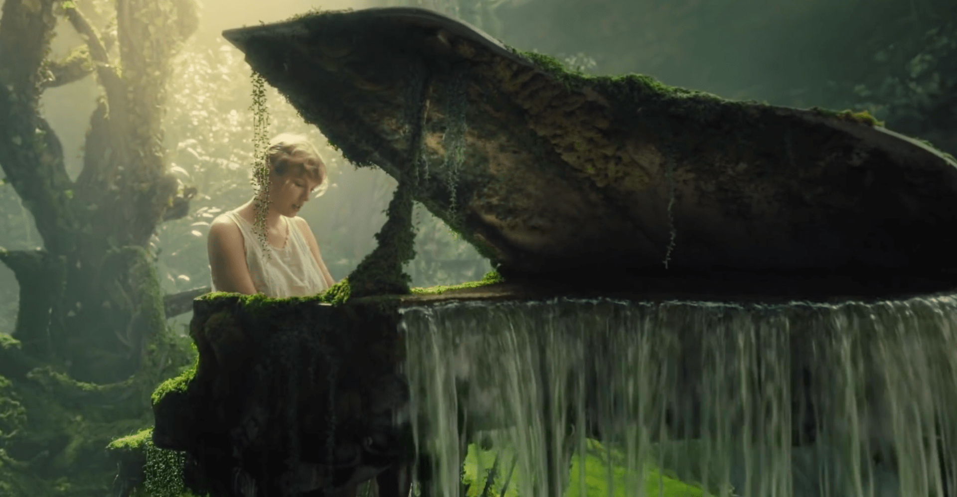 a young blond woman playing a piano overgrown with moss in a lush forest