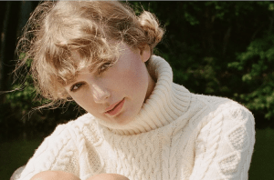 blond woman in white knit turtle neck leaning over in the sunshine
