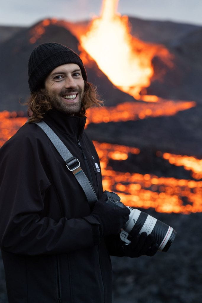 man with camera in front of a volcano