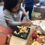 Preschool student cutting apples