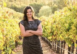 Stephanie appears in a vineyard, reminiscent of her viticulture background.