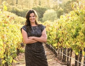 Stephanie appears in a vineyard, reminiscent of her viticulture background.
