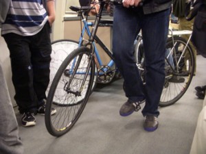 A bicycle on a BART train with paper applied to the spokes of the rear wheel