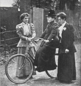 19th-century photograph of F. Willard on her bicycle Gladys, supported by two women