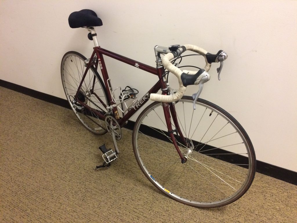 maroon road bicycle with white handlebar tape