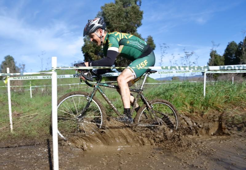 cyclist riding through a mud puddle