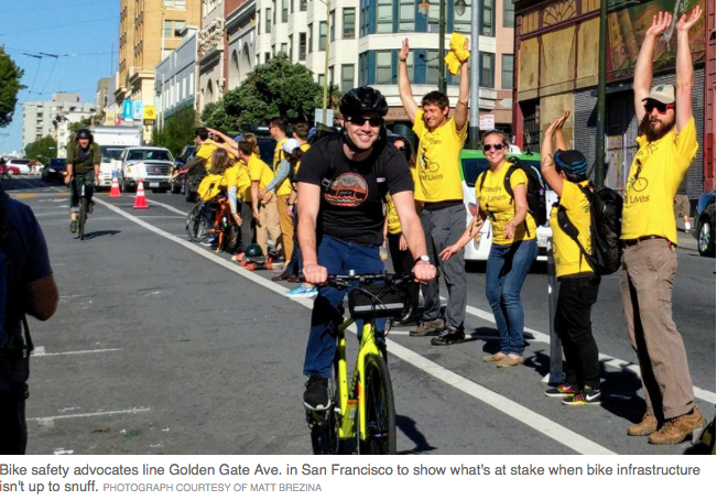 people in yellow shirts forming a human fence between bike lane and automobile lane