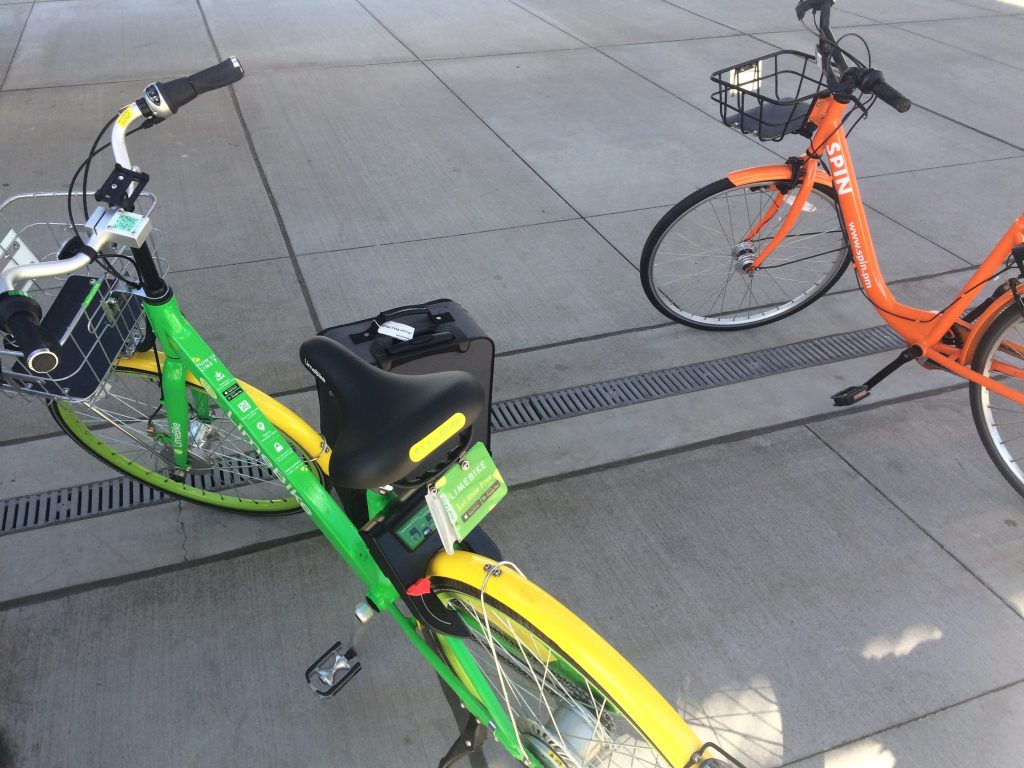 two brightly colored bicycles, one bright green and yellow, the other orange