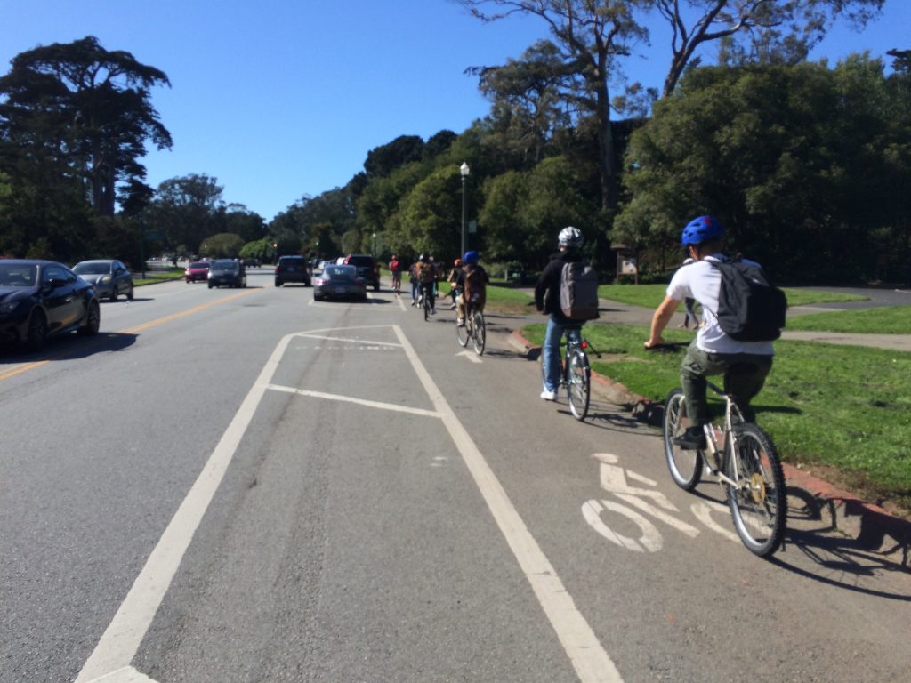 students on bicycles riding in bike lane on John F. Kennedy Drive