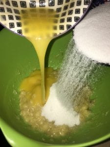 Pouring banana muffin ingredients into the same bowl.