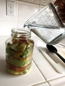 A jar filled with apple scraps and water.