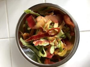 A bowl full of apple peels and other scraps.