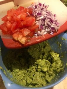 Mashed guacamole in a bowl before other ingredients are added.