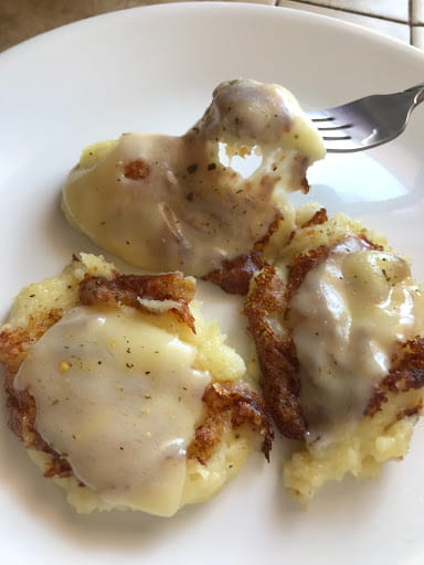 Melted cheese on three mashed potato dollops.