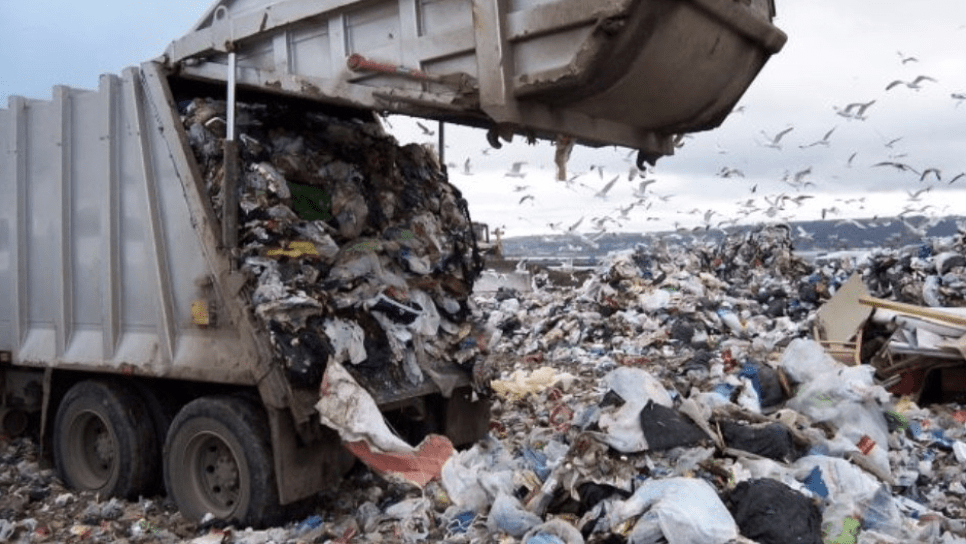 Dump truck unloading in a landfill.