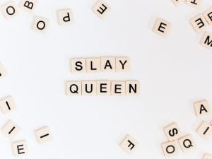 Scrabble letter pieces spelling out "Slay Queen"