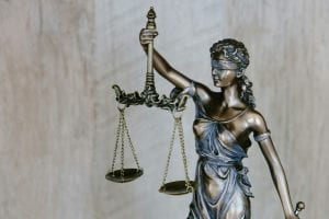 The image depicts Lady Justice raising scales. The image is titled "Lady Justice background," and it is credited to the Tingey Injury Law Firm, West Charleston Boulevard, Las Vegas, NV, USA.